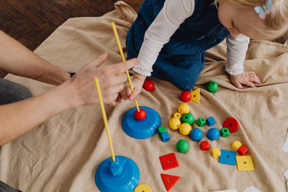 A compassionate professional helping a child with educational toys